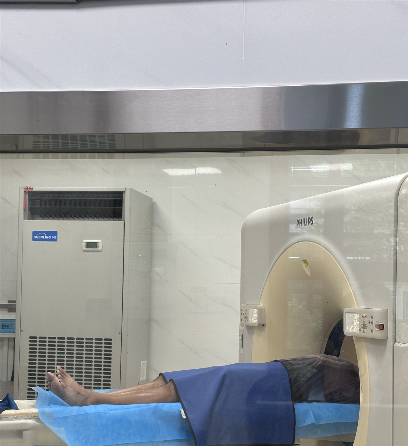 A visitor positioned on an examination table in an imaging room during the Shenzhen visit